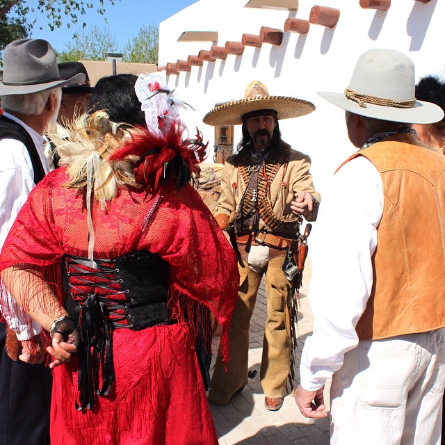 a group of people in traditional mexican clothing in the courtyard of a house