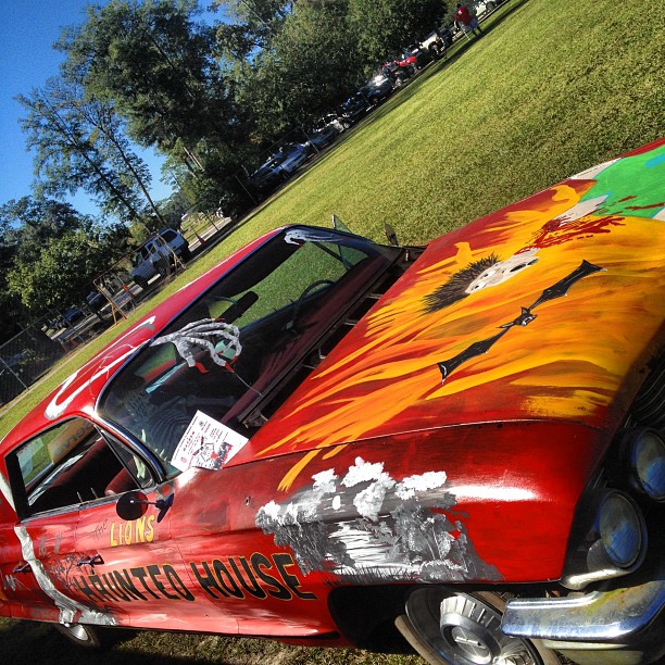 a painted car sitting in the middle of a grassy area