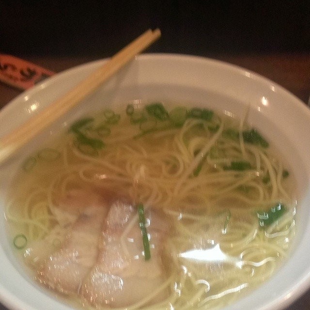 a bowl of asian noodle soup with chicken and green onions