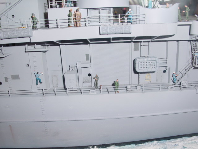 a white boat with some people standing on the deck