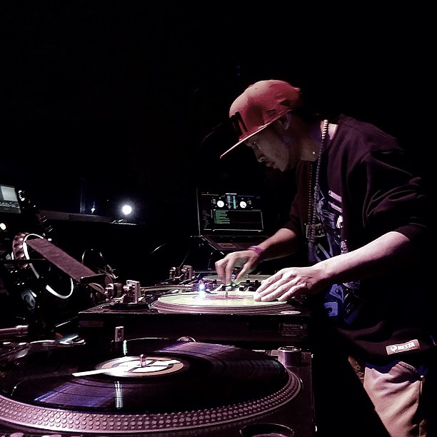 a dj at a turntable and some lights