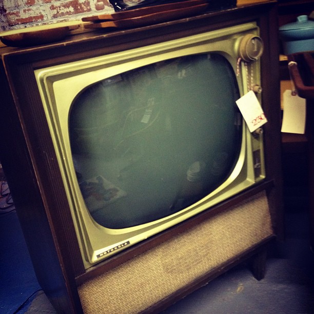 an old television on top of an antique table