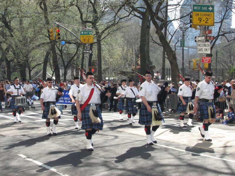 some people in tartans are marching in the street