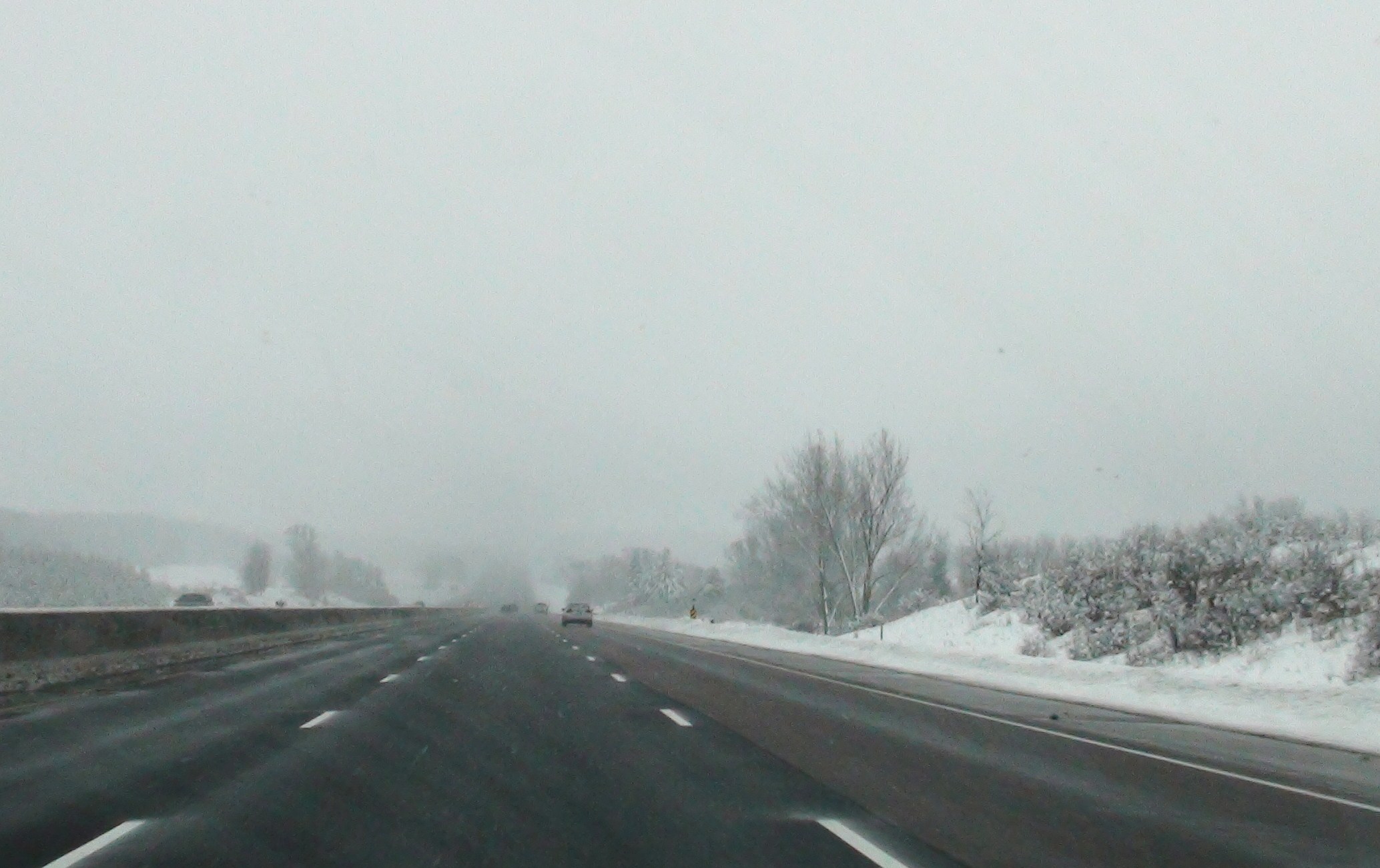 a car driving down a snow covered highway