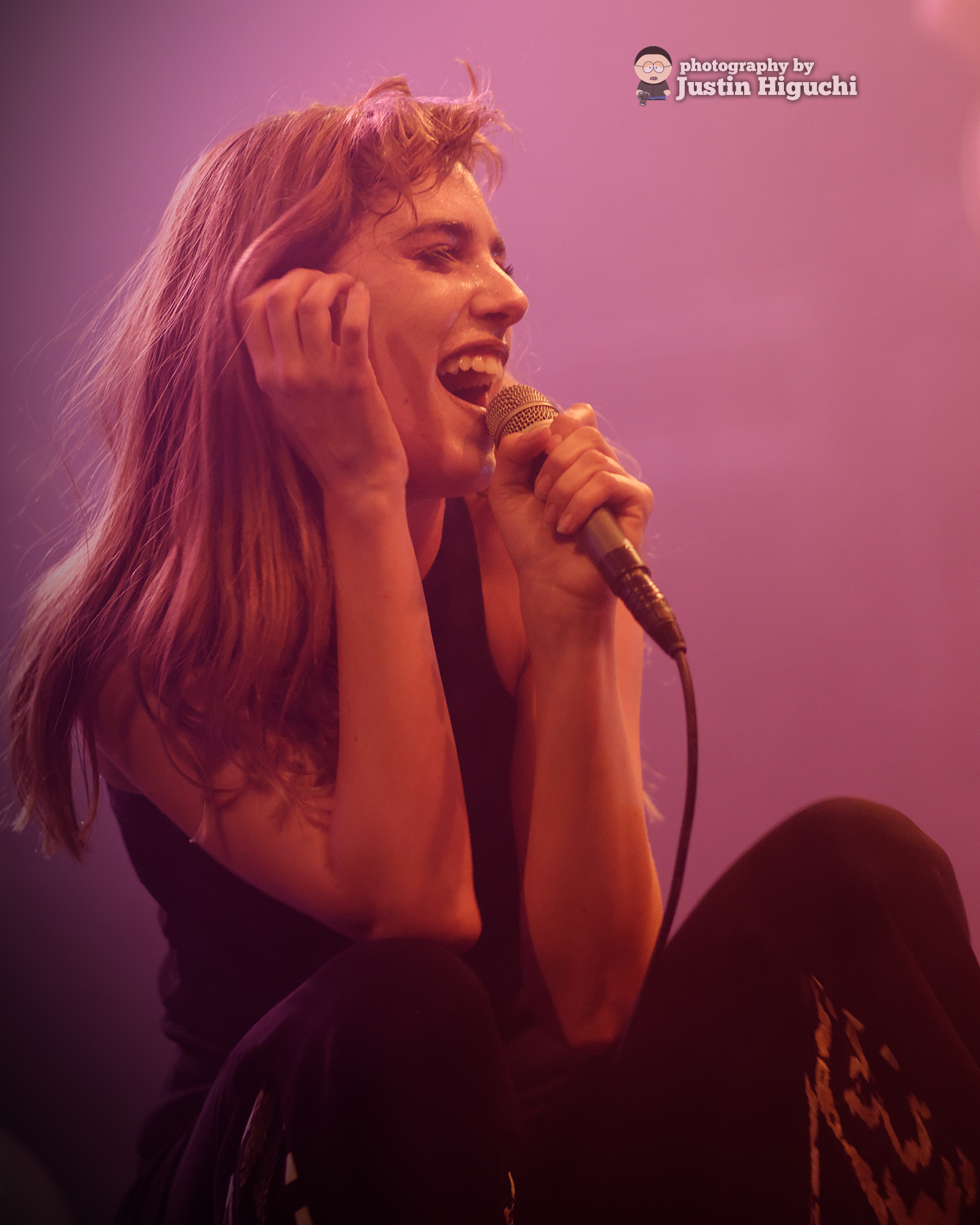 a woman is holding a microphone while singing