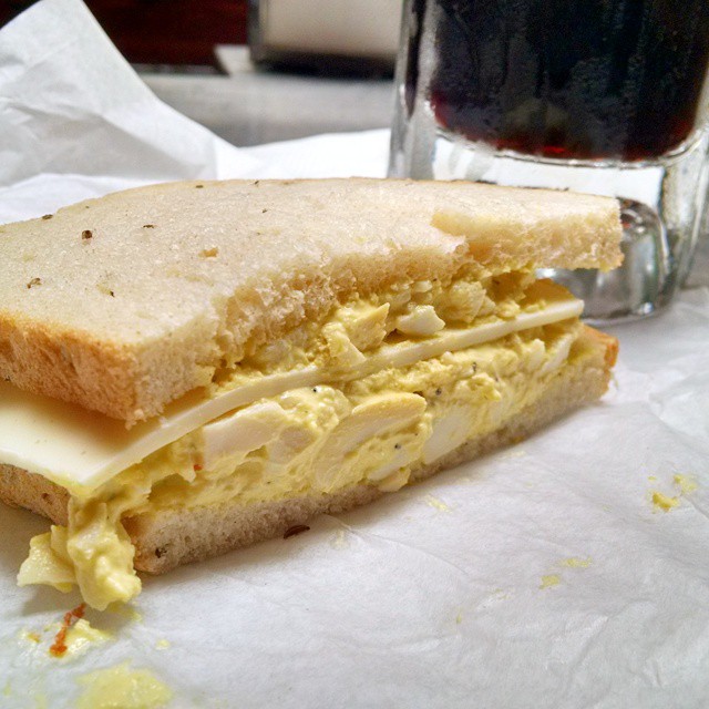 a close up of a sandwich near a cup