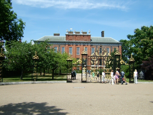 a large building behind a gate with trees around it