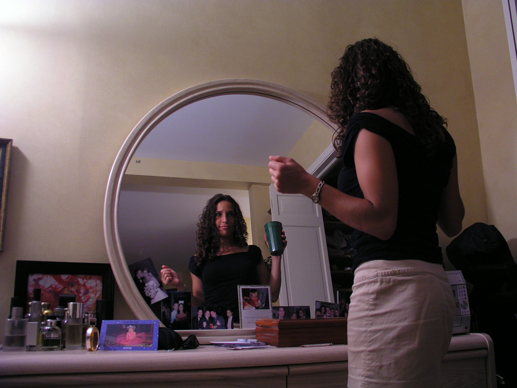 two women stand in front of a mirror