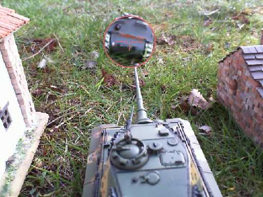 an old toy car, mirror and brick structure in the grass