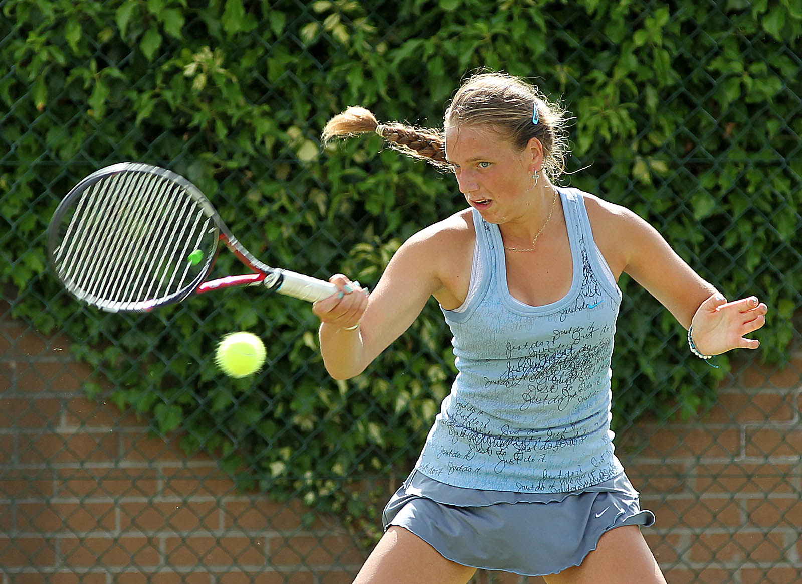 a woman hits a tennis ball on the court