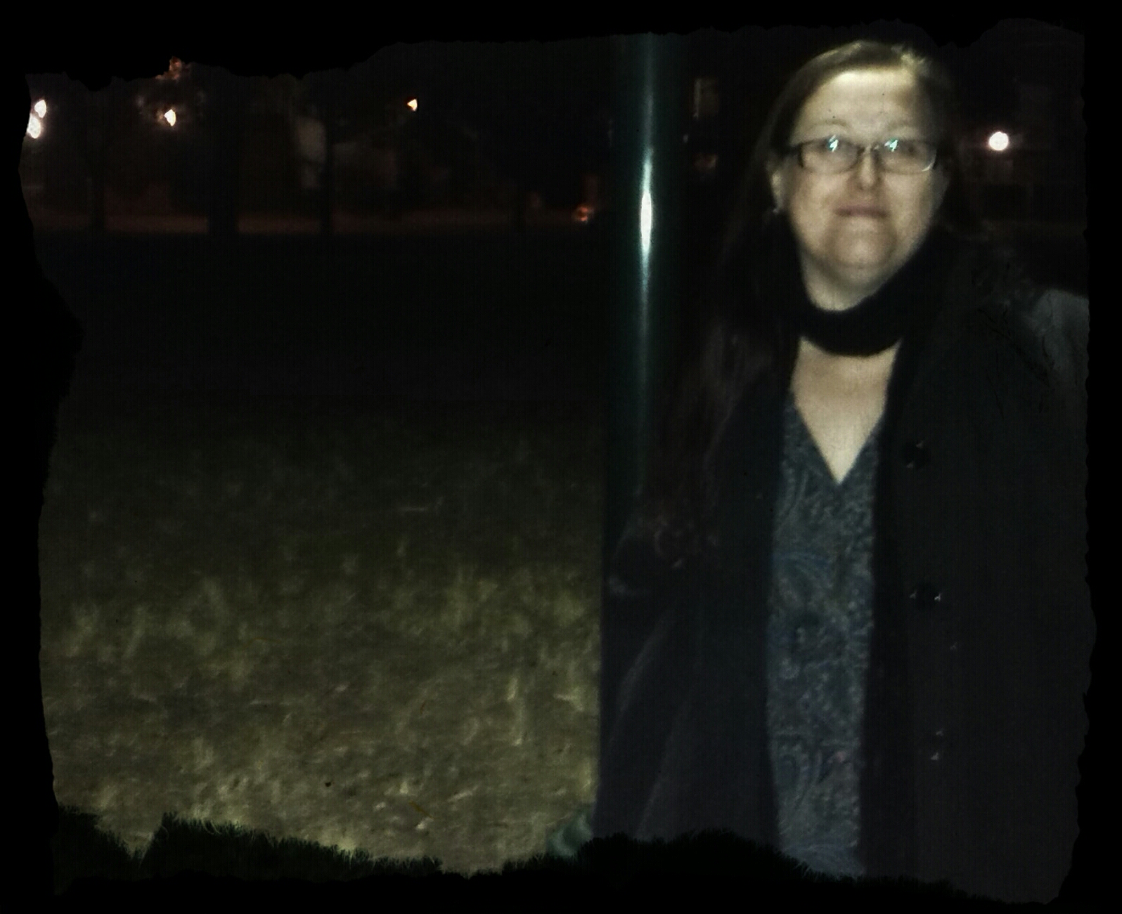 a woman posing for a picture outside in the night