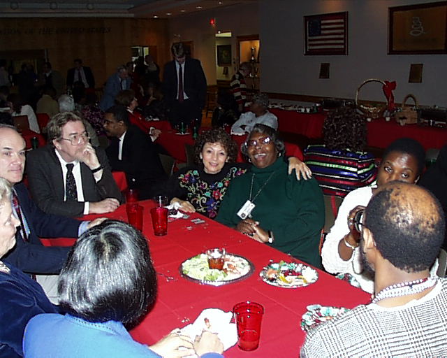 people are seated at a restaurant table having drinks