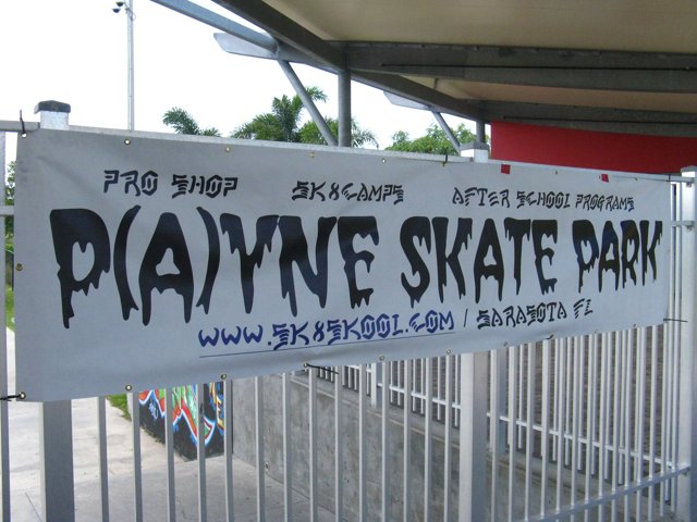 a sign advertising a skate park attached to a fence