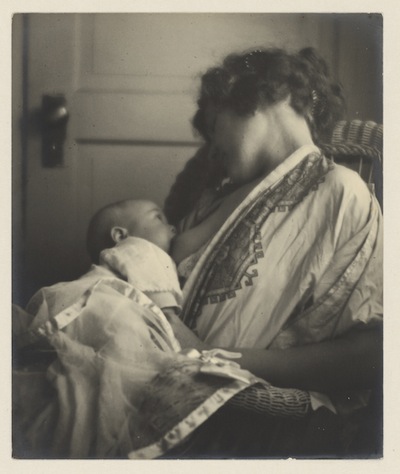 a woman holding a baby while sitting down