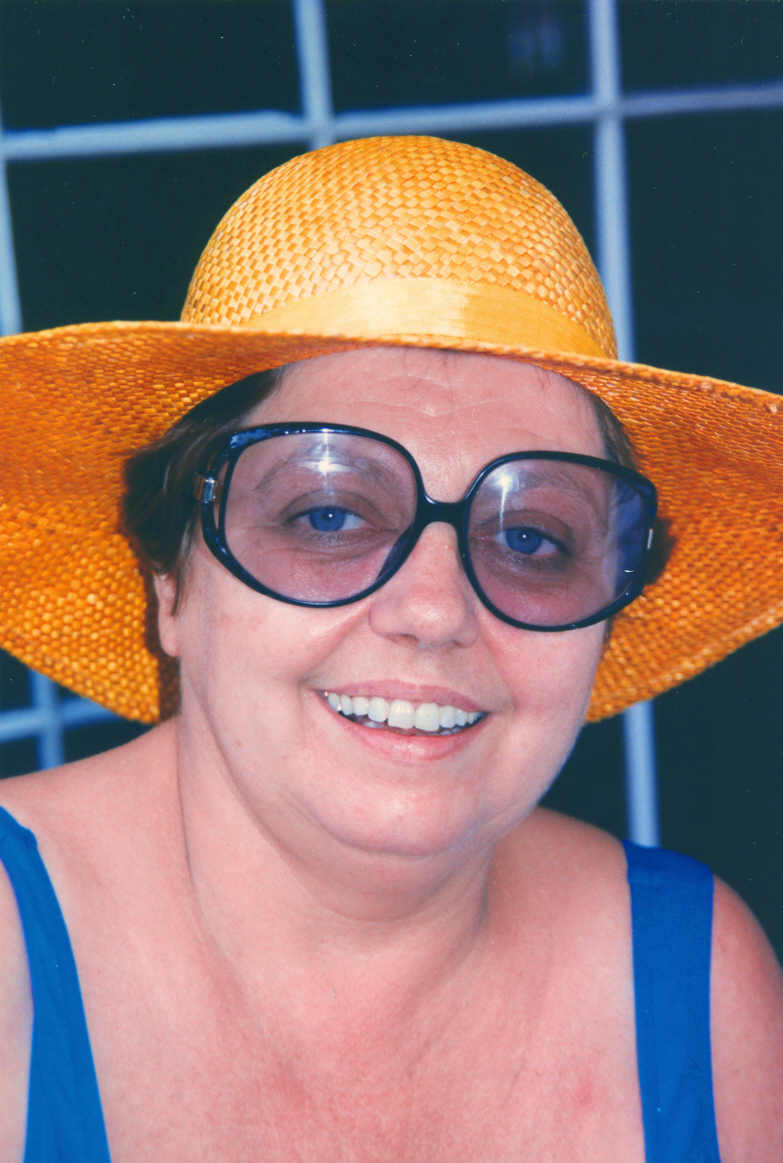 a woman wearing a big hat and glasses posing for the camera