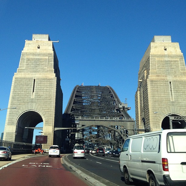 vehicles drive on the freeway under a bridge