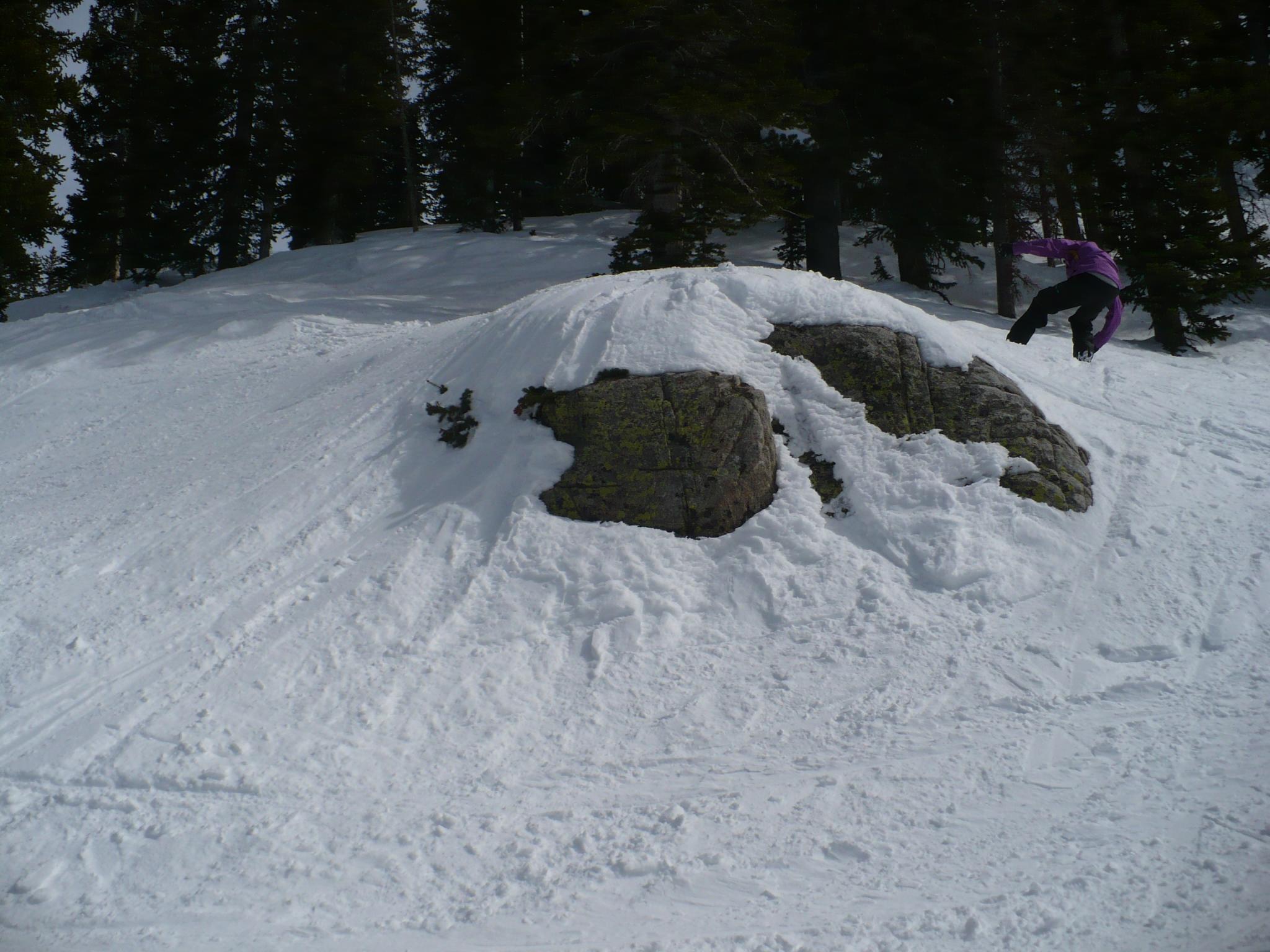 a person riding skis down the side of a snow covered hill