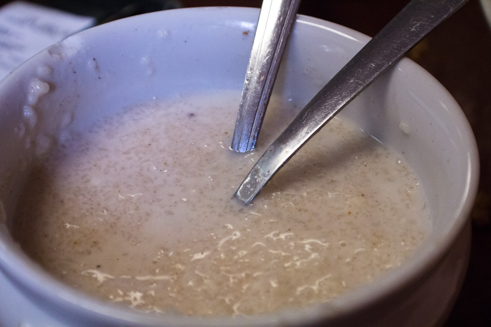 two spoons sticking out of the soup in a bowl