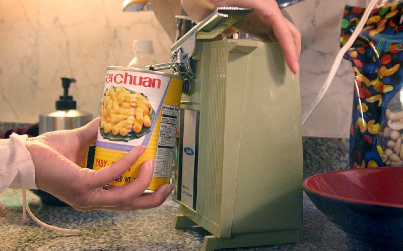 a person is putting food in a container into a toaster