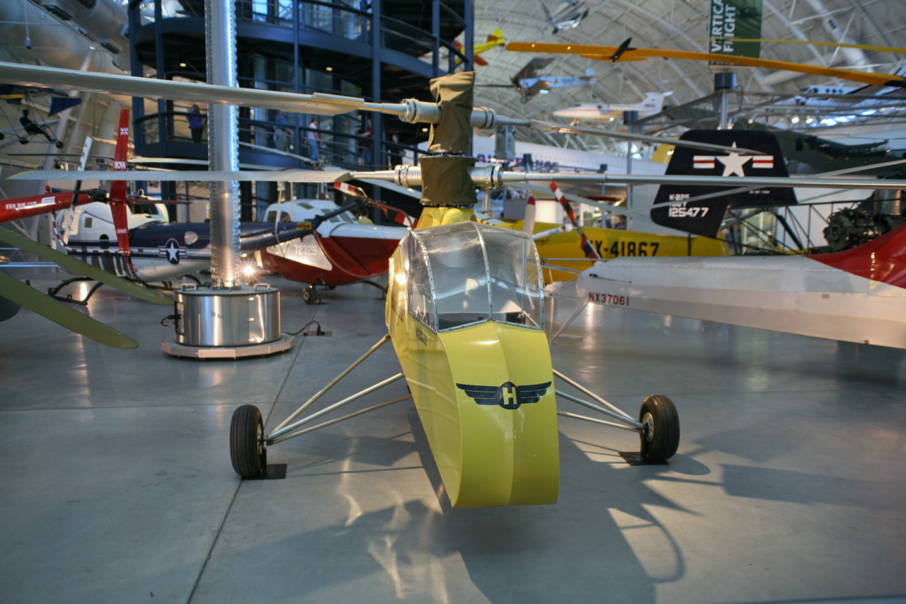 a yellow propeller plane sits in a hanger