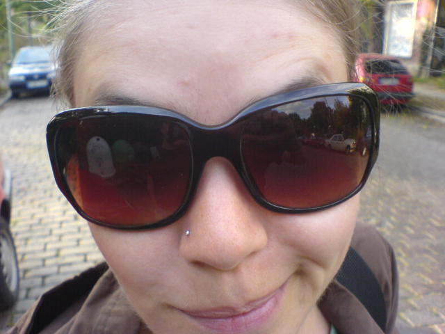 a woman with her sunglasses on outside wearing soing else