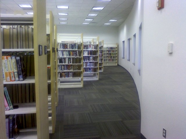 an empty liry with rows of books and ladders