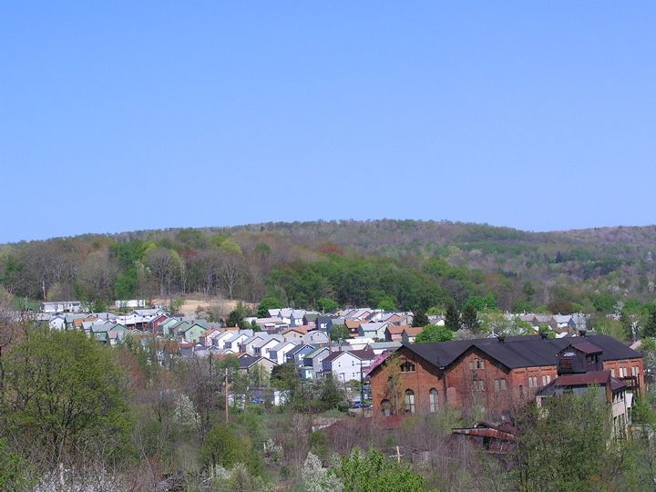 an area with buildings, and trees on the hill