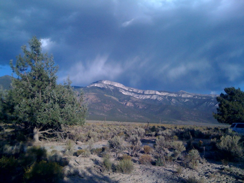 a cloudy day in the mountains near a blue truck