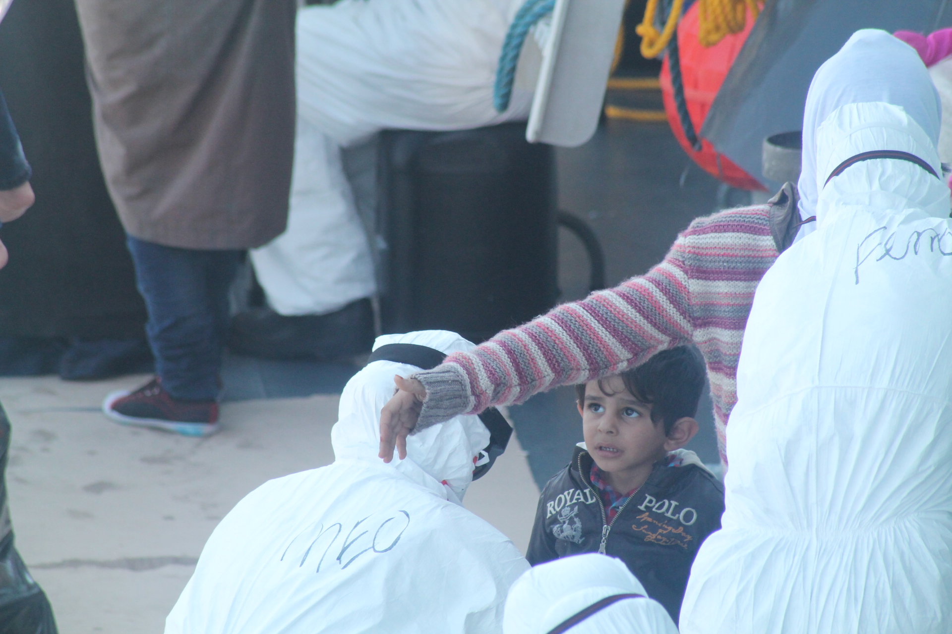 an elderly woman handing out some bags to a small boy