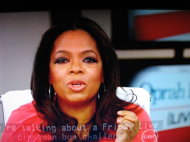 a close up of a woman on the television talking into a microphone