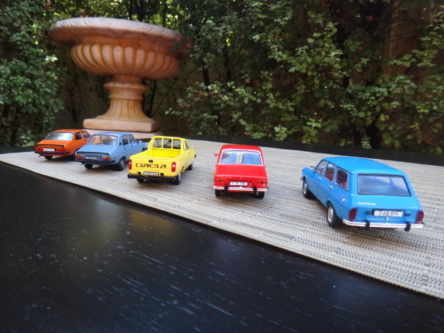 some miniature cars parked on a wood shelf