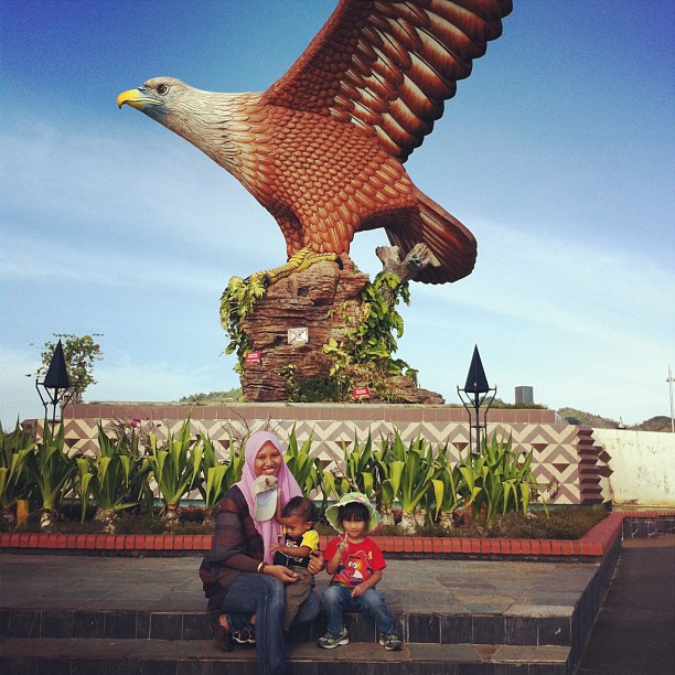 the woman and two children are posing with an eagle statue