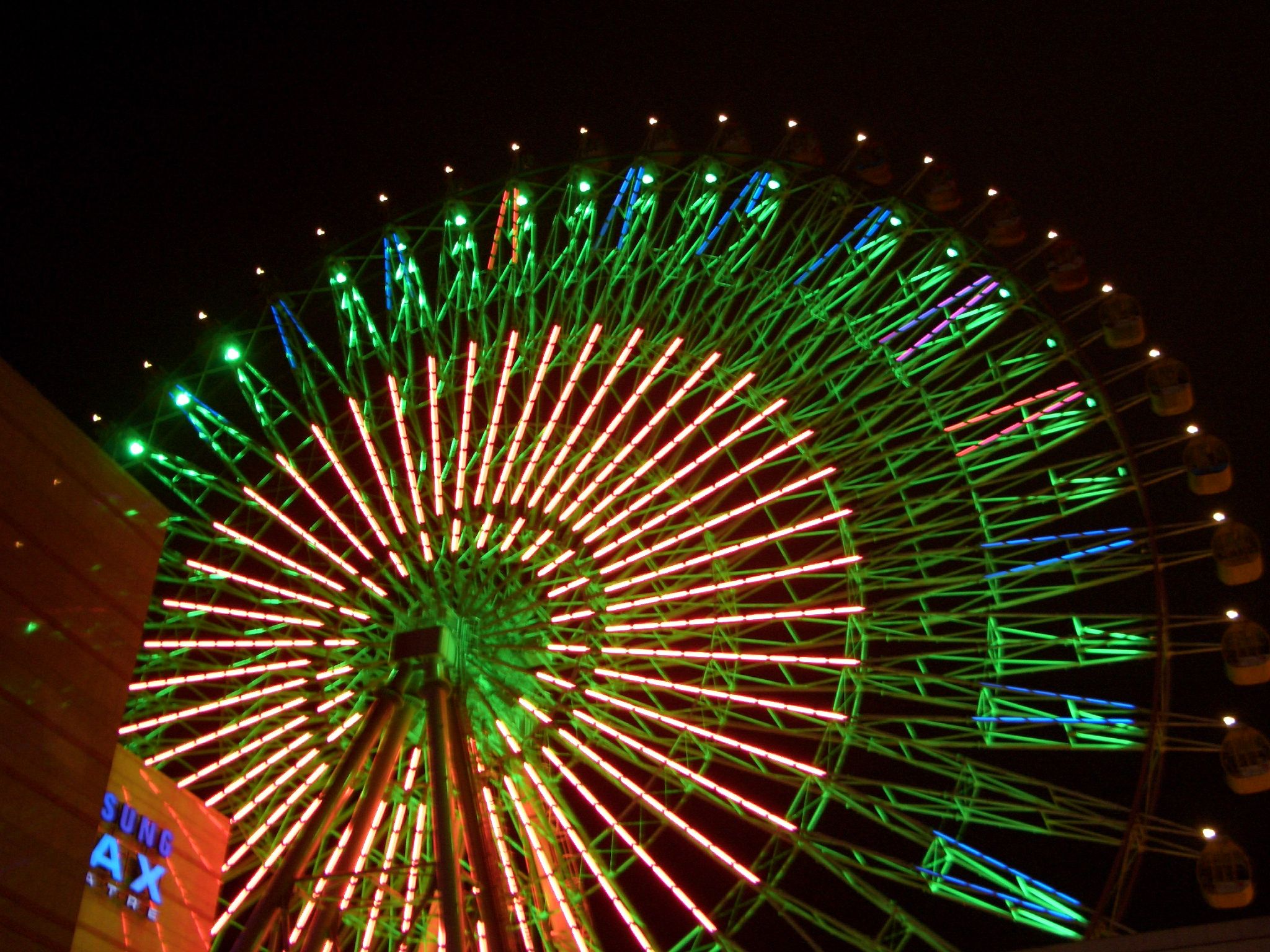 bright colorful lights shine on the large ferris wheel