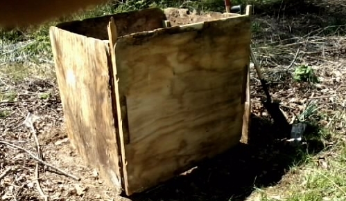 an open wooden box sits in a field