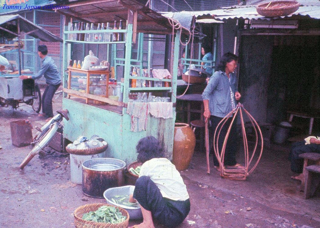 many people who are sitting outside of their shacks