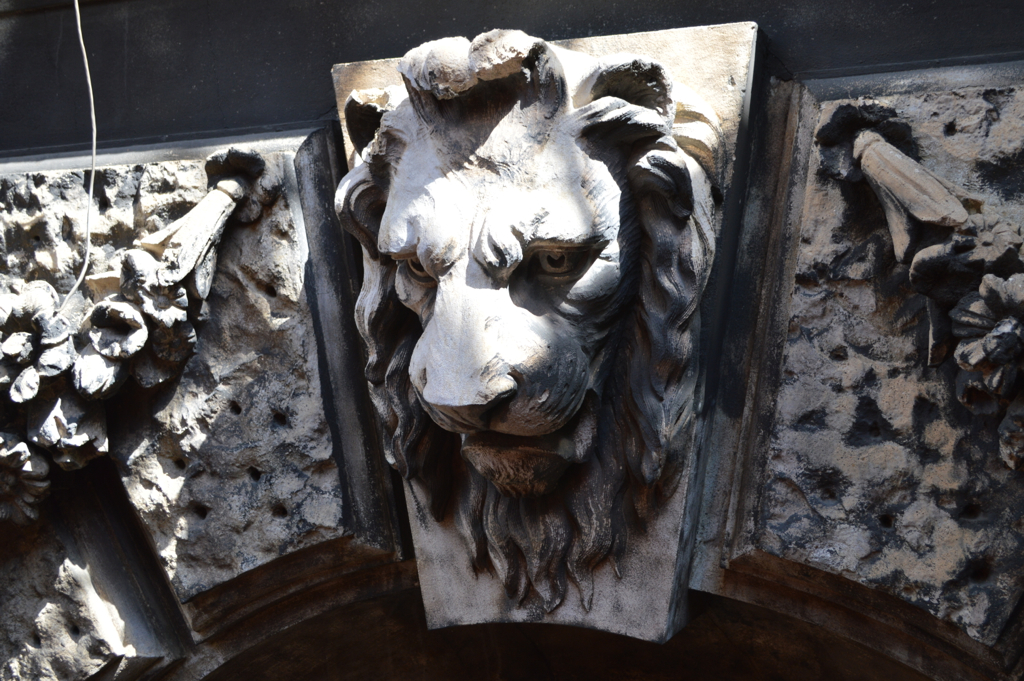 a carving of a lion's face is pictured on the side of a building