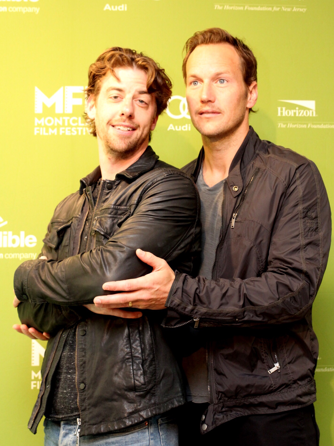 two men with arm wrapped around each other pose for the camera