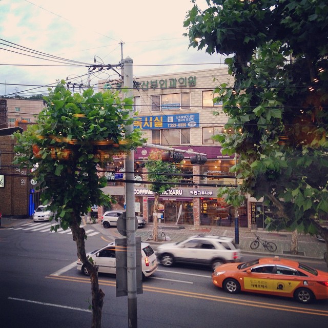 traffic travels along a street next to a business