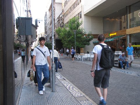 many people on a street with a large building