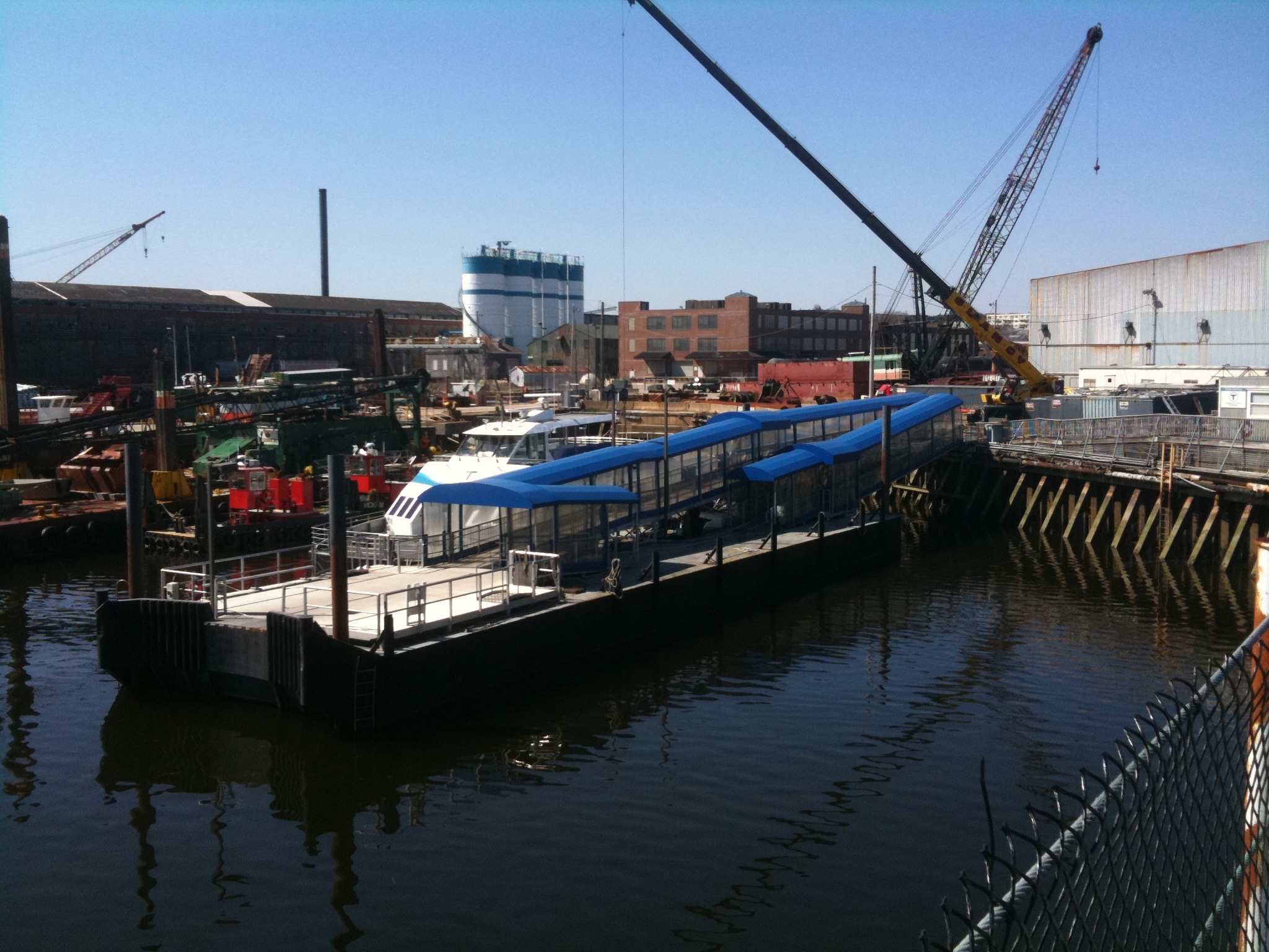 a barge docked in the middle of the harbor with lots of equipment