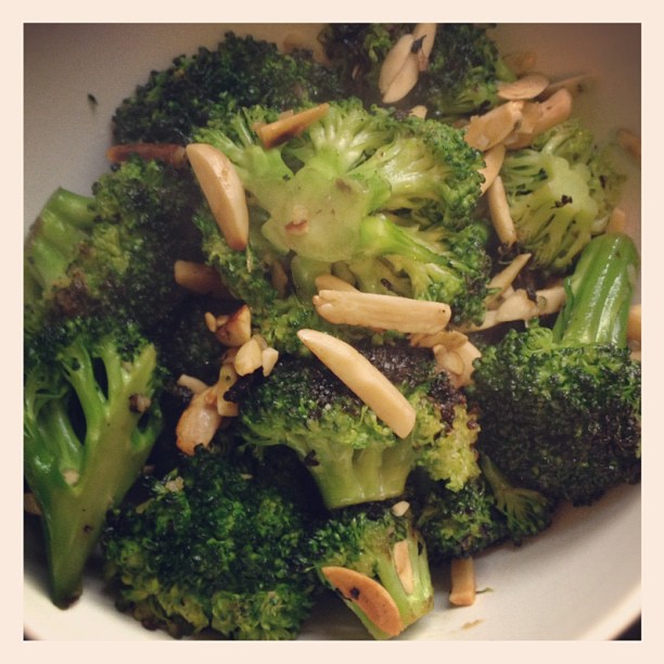 a bowl of broccoli with nuts and almonds