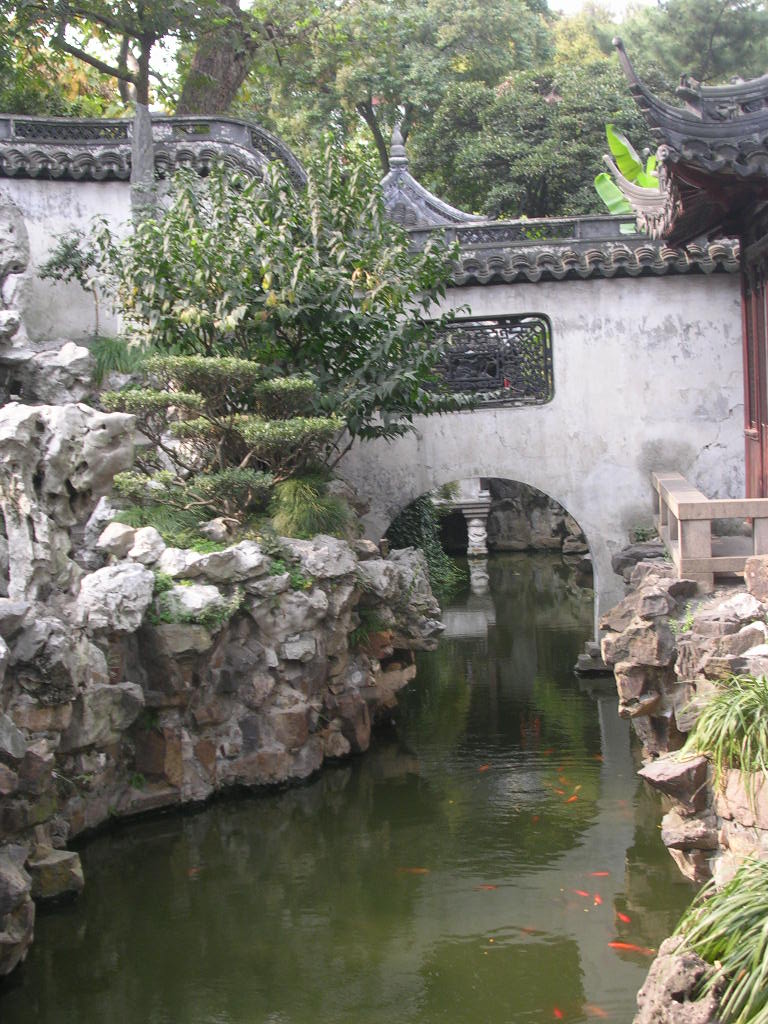 the pond is a reflection in a pool surrounded by stone walls