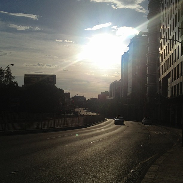 the sun is shining on a city street