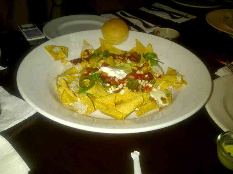 a plate filled with nachos on top of a table