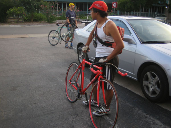 an individual on his bicycle with others in the background