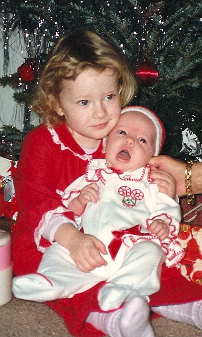 a  in red holding a baby in her arms