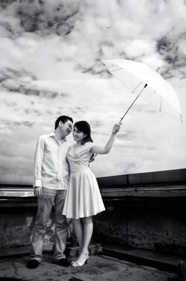 a couple standing under an umbrella on a cloudy day