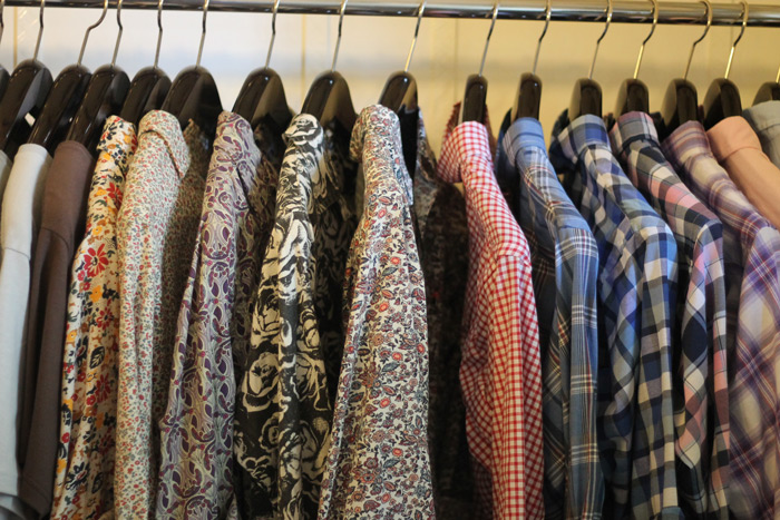 many different shirts hanging in the closet