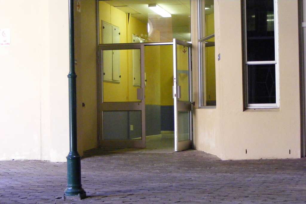 a corner of an empty building with glass doors
