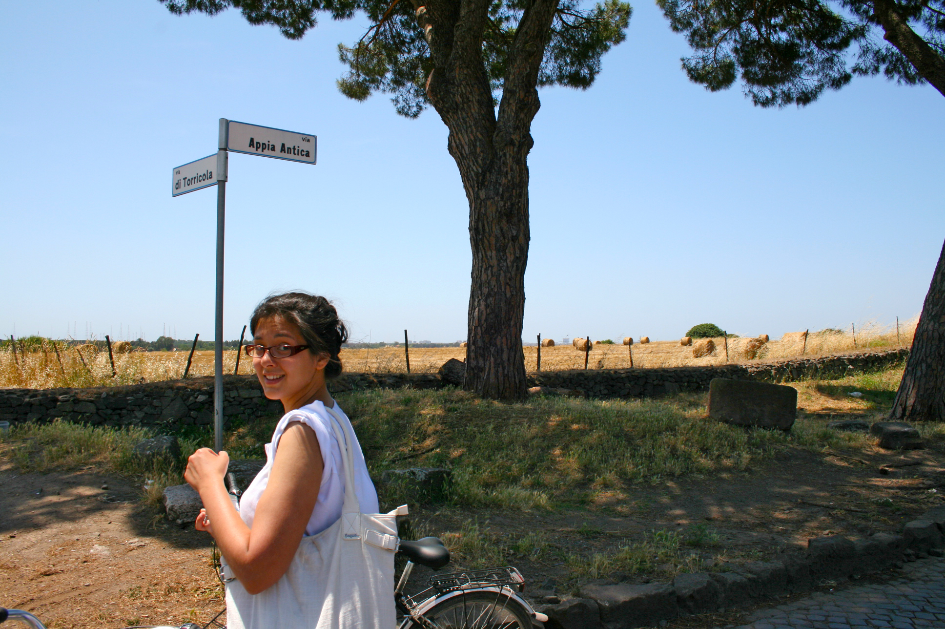 a girl standing in front of a sign and bike